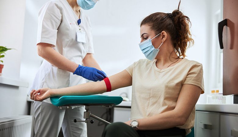 kobieta trzymająca się za głowę w ciemnym pomieszczeniu